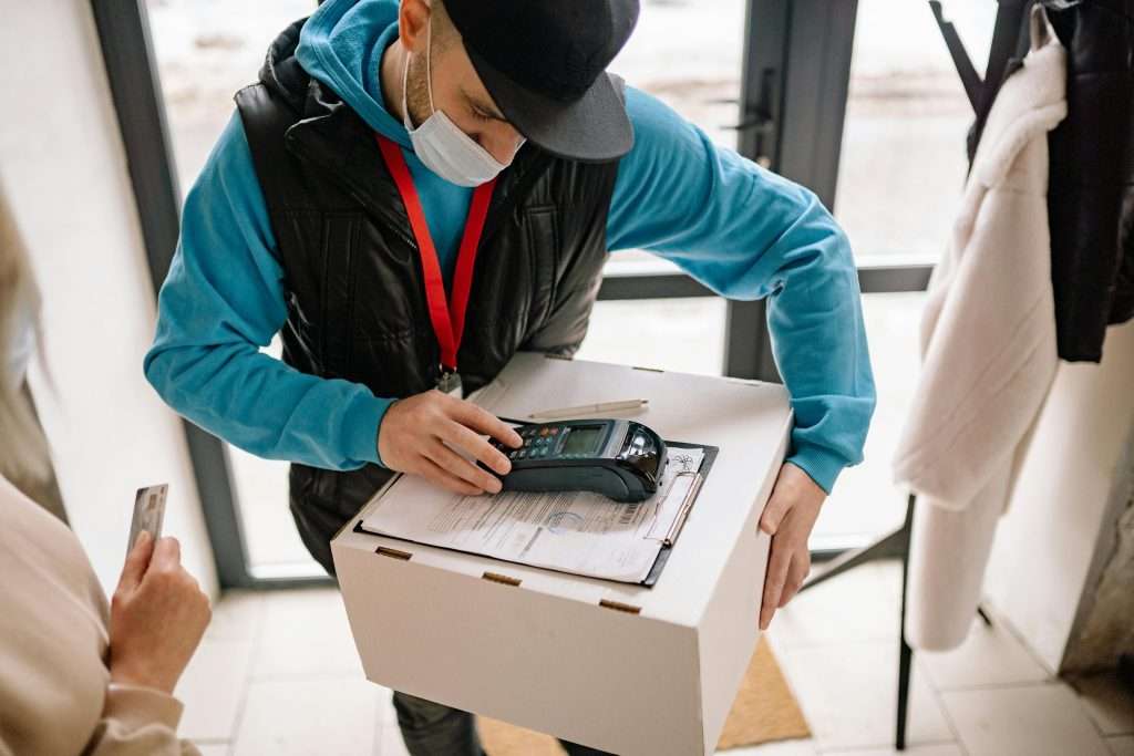 Delivery boy taking payment through portable card machines