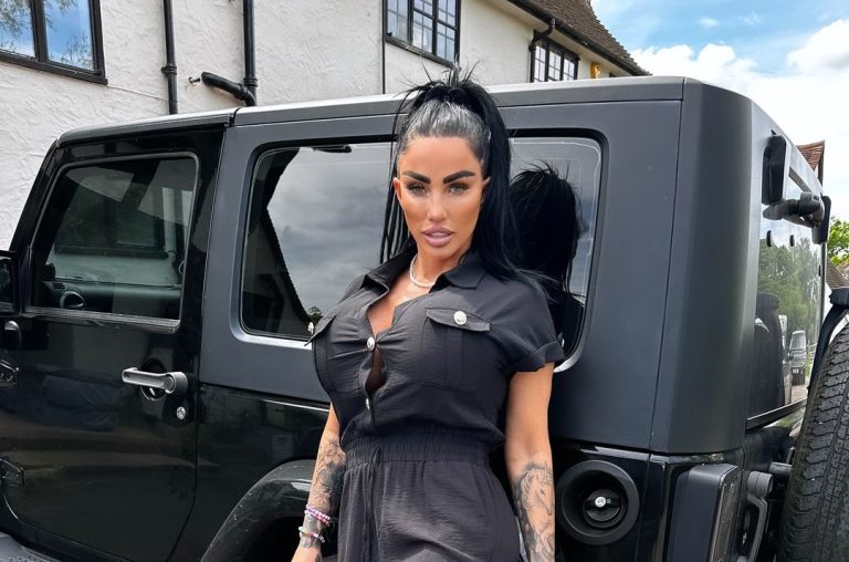 Katie Price posing in black dress in front on a black car