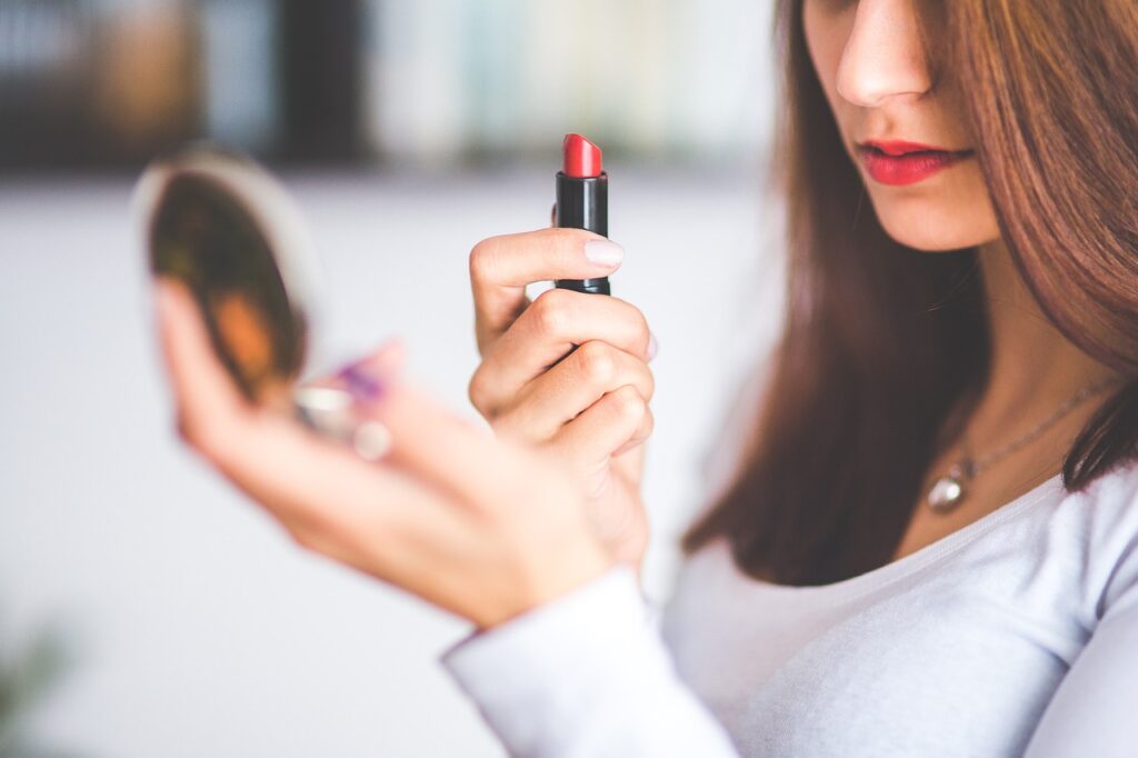 a woman is doing makeup on small mirror