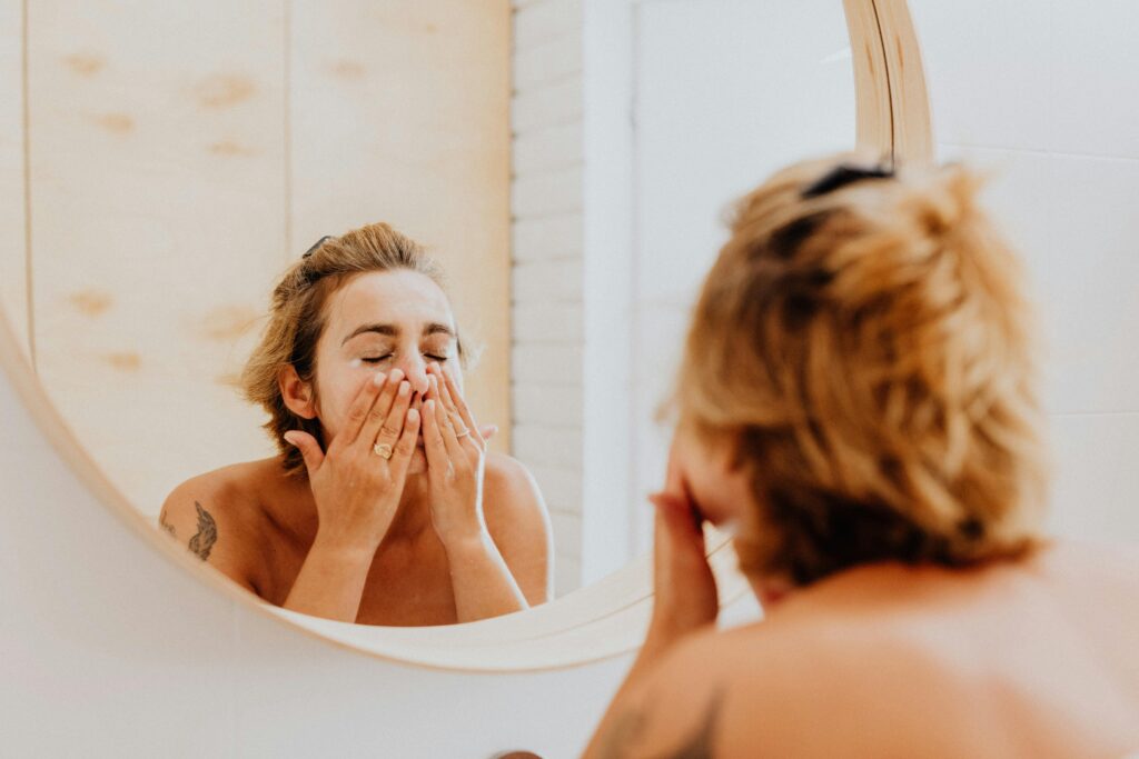 a woman is cleaning her face